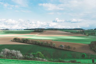 Scenic view of field against cloudy sky