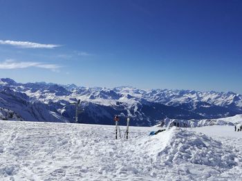 Rear view of person skiing on snowcapped mountains against clear blue sky