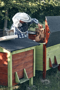 Bee keeper working while standing in park