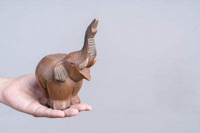 Human hand holding rock against white background