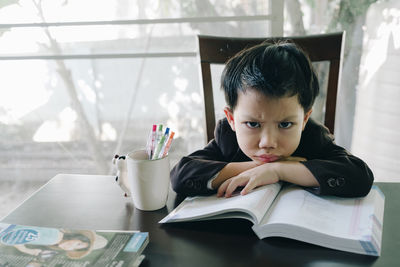 Portrait of boy sitting on table