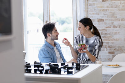 Young man and woman sitting on table