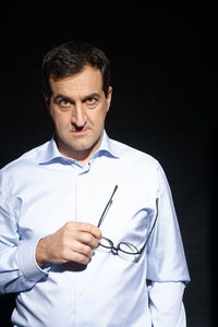 Portrait of man wearing mask against black background