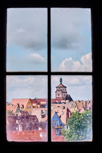 Buildings against sky seen through glass window