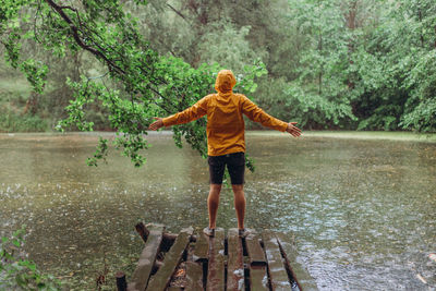 Rear view of boy standing by lake