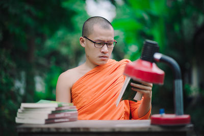 Portrait of young man sitting on book