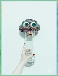 Close-up of woman holding hands over white background