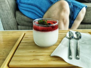 Midsection of woman holding coffee on table