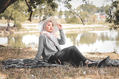 Portrait of young woman sitting on field