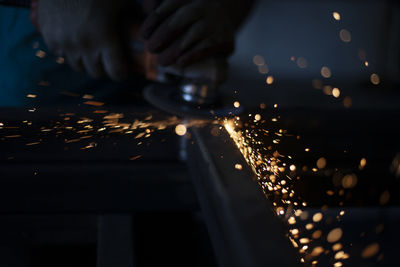 Sparks in dark. metal grinding. orange lights fly in different directions. work in metal workshop. 