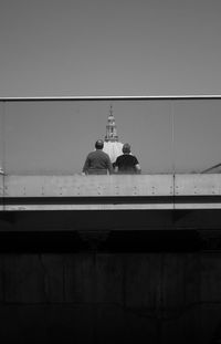 Rear view of people on bridge against dome