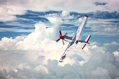 Low angle view of airplane flying against sky