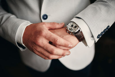 Midsection of businessman wearing suit and watch