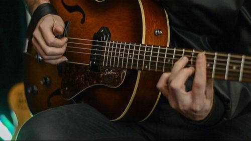Midsection of man playing guitar
