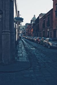 Street amidst buildings against clear sky
