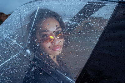 Portrait of young woman with umbrella outdoors