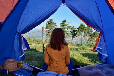 Rear view of woman sitting on tent