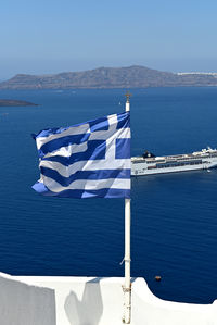 Scenic view of flag and sea against sky