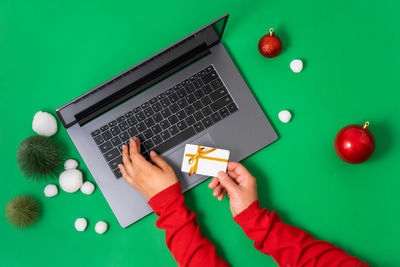 Cropped hands of woman using laptop on table