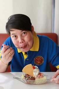 Portrait of woman eating ice cream in cafe