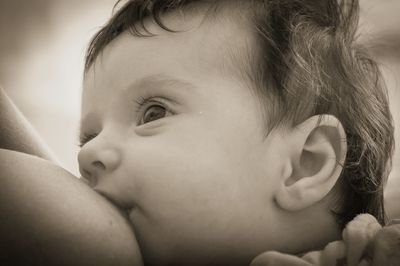 Close-up of mother breastfeeding cute baby