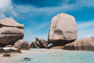 Rocks on sea shore against sky