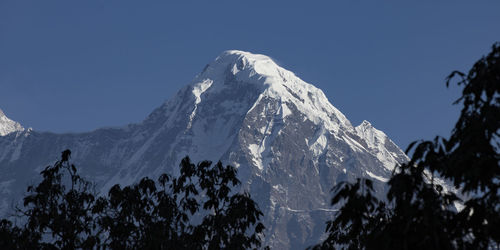 Low angle view of snowcapped mountains against clear sky