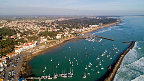 High angle view of city by sea against sky