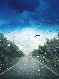 Waterdrops on glass with view of road seen through wet window