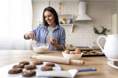 Mid adult woman having food at home