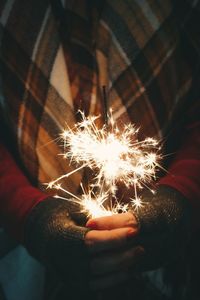 Close-up of hand holding sparkler at night