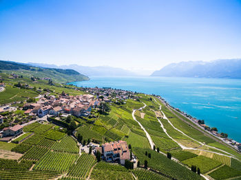 High angle view of agricultural field by sea against sky