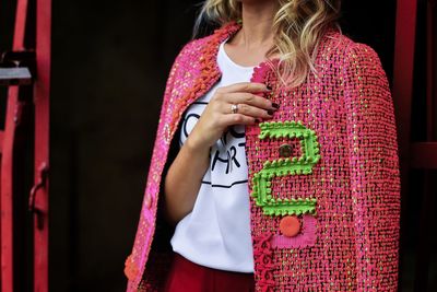 Midsection of woman wearing pink jacket on doorway