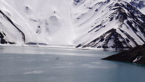 Scenic view of frozen lake by snowcapped mountain