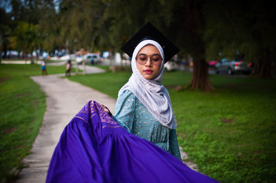 Portrait of smiling young woman standing on land