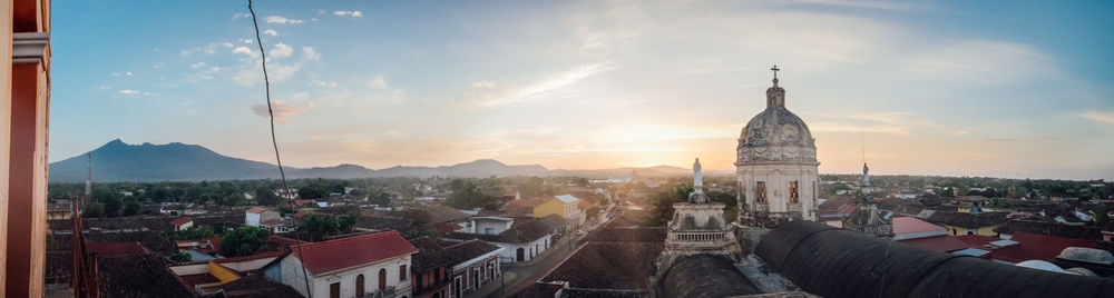 Panoramic view of buildings in town against sky during sunset