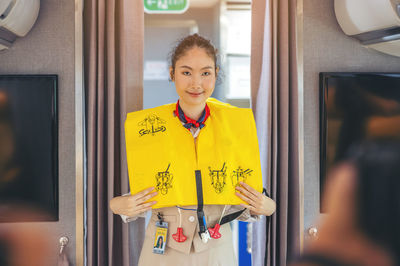 Prior to the flight's takeoff, an air hostess presents safety procedures to passengers.