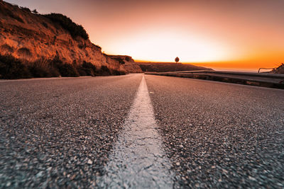 Surface level of road against clear sky during sunset