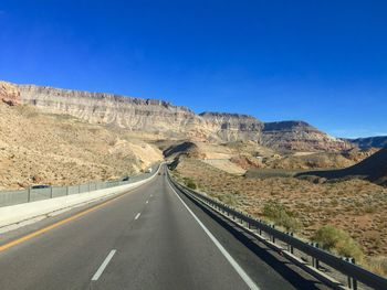 Road on mountain against clear blue sky