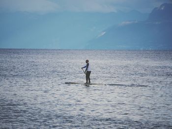 Man paddleboarding in sea