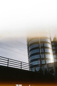 Low angle view of modern building against sky during sunset