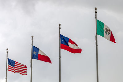 Low angle view of flag flags against sky