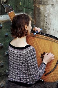 Rear view of woman playing with musical instrument