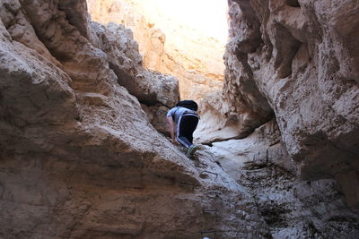 Rear view of man rock climbing at wadi og
