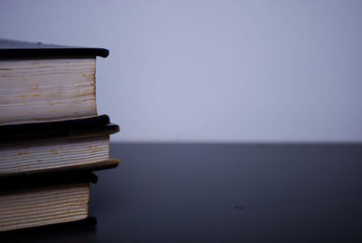 Close-up of stack of books against sea against sky