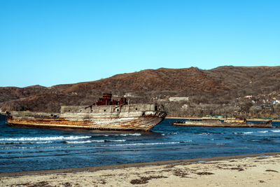 Scenic view of beach against clear blue sky