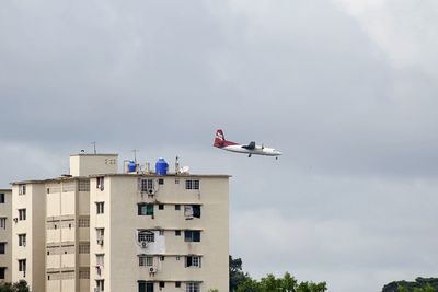 Low angle view of airplane flying against sky