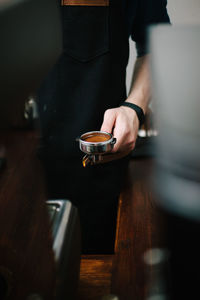 Man holding coffee cup on table