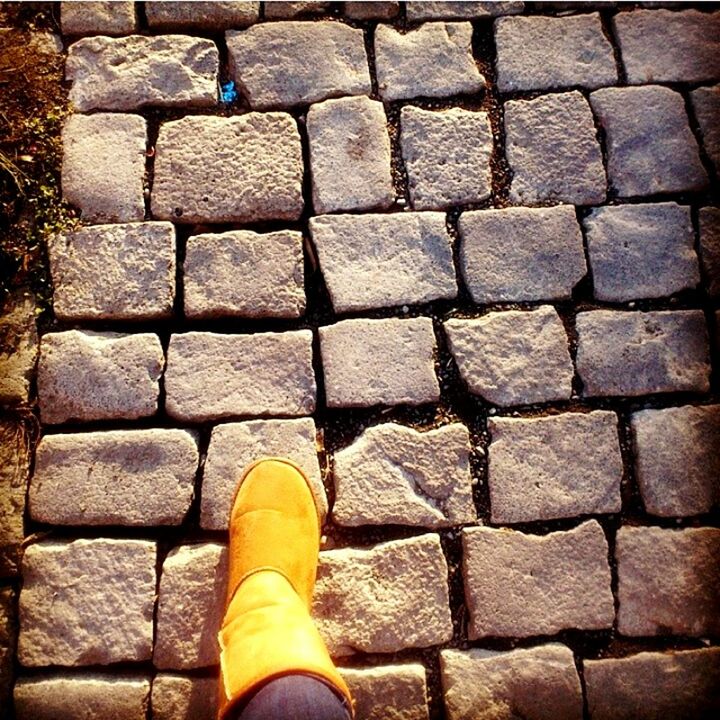 cobblestone, shoe, low section, person, personal perspective, paving stone, pattern, brick wall, standing, textured, high angle view, outdoors, brick, part of, day, close-up, street