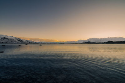 Scenic view of lake tekapo against sky at dawn